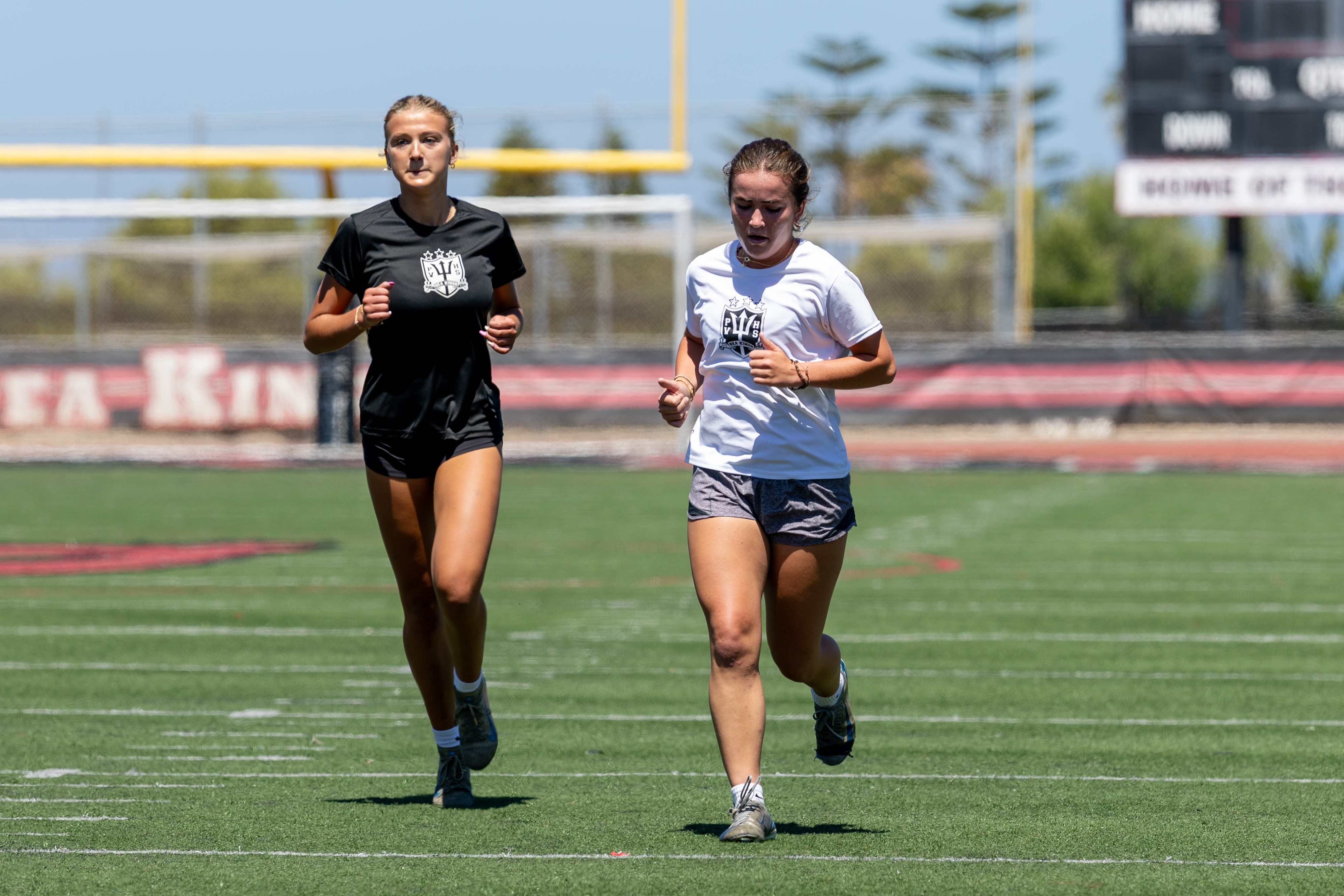 Coach guiding a women's athlete through a training drill