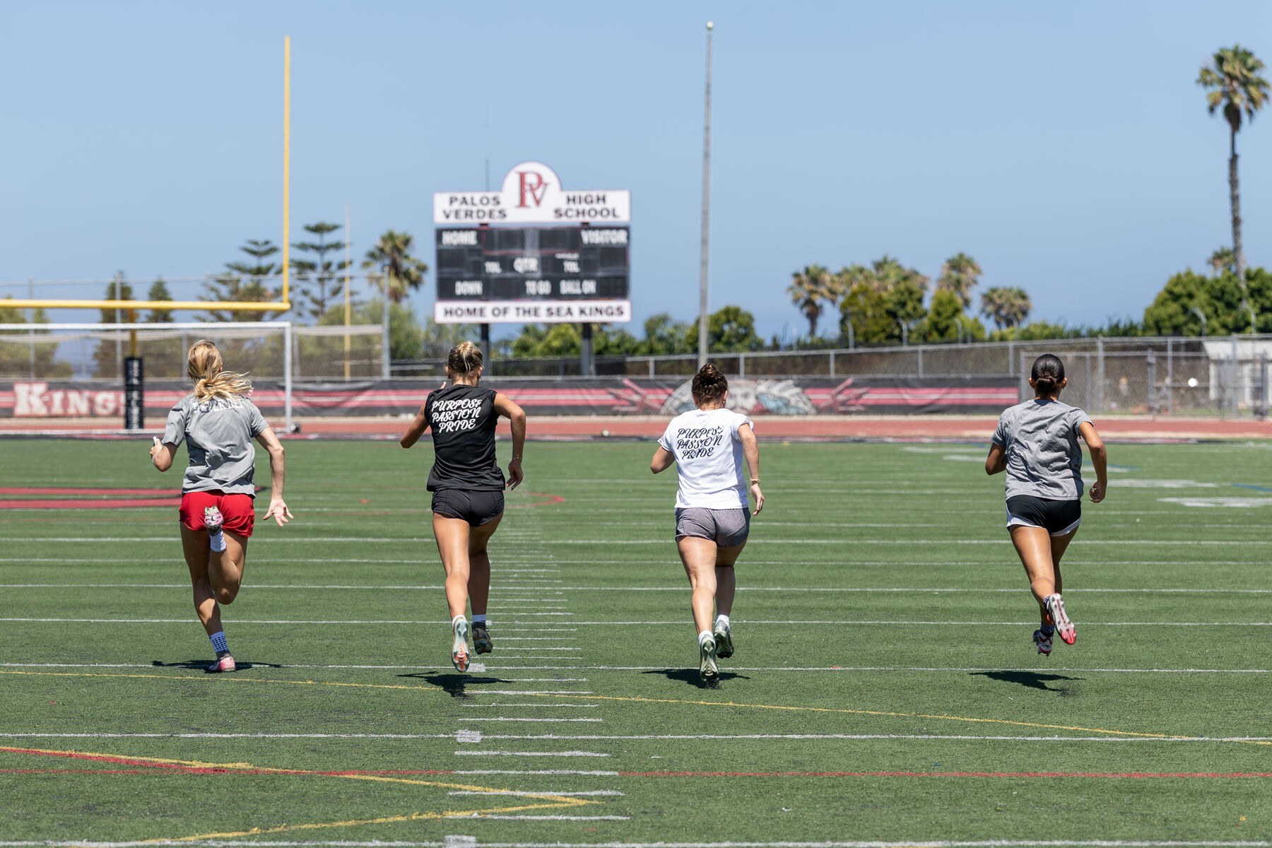 Four women's athletes sprinting during conditioning training