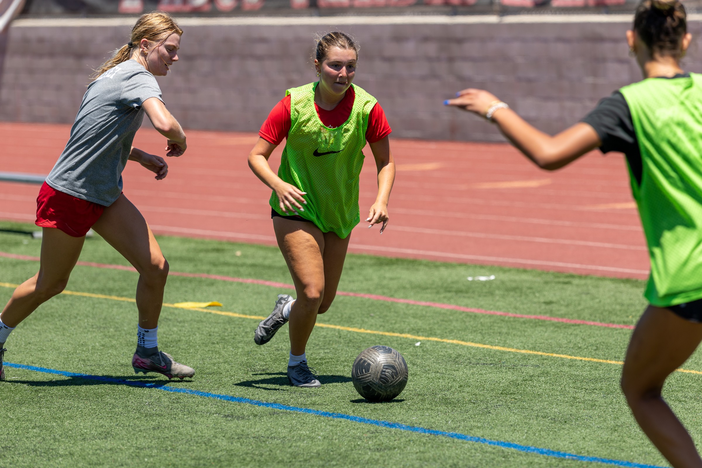 Women's team athletes competing for the ball during a training match